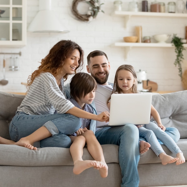 Happy family on couch looking at laptop