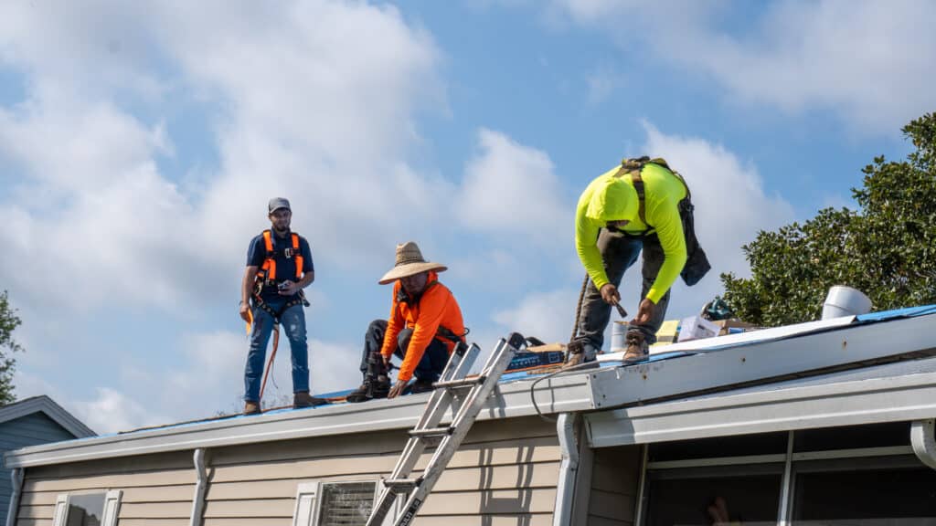 Trio of florida roofers working on a roof replacement