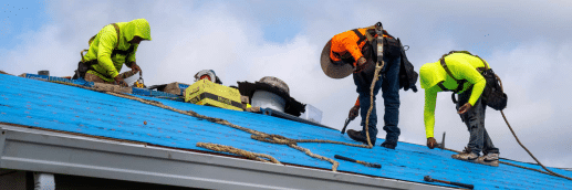 Three men installing a new shingle roof